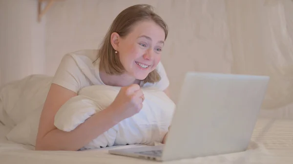 Ung Kvinde Fejrer Bærbar Computer Mens Ligger Maven Sengen - Stock-foto