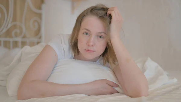 Seriös Ung Kvinna Tittar Kameran Medan Sitter Armbågen Sängen — Stockfoto