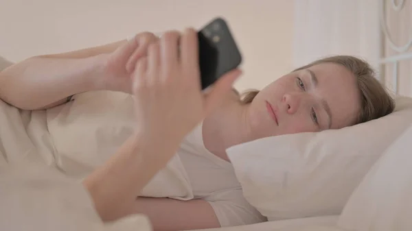 Widok Boku Młodej Kobiety Pomocą Smartfona Łóżku — Zdjęcie stockowe