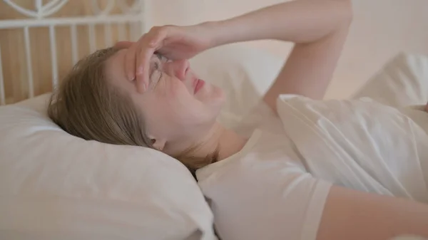 Yatakta Yatan Baş Ağrısı Olan Genç Bir Kadının Yan Görüntüsü — Stok fotoğraf