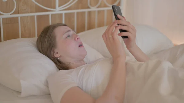 Mladá Žena Šokována Ztrátou Smartphonu Při Ležení Posteli — Stock fotografie