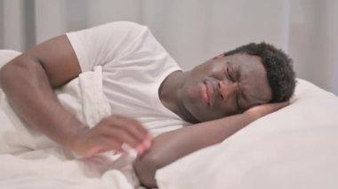 Diş ağrısı olan yetişkin bir adam. Yatakta yan yatıyor.