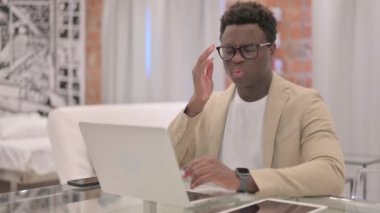 Başağrısı olan yetişkin bir adam laptopta çalışıyor.