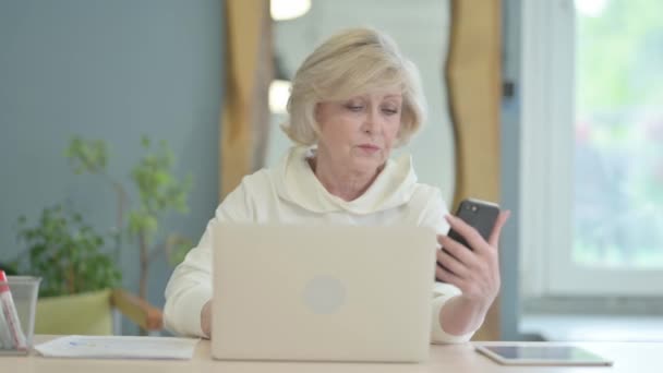 Зрелый Взрослый Человек Работает Над Ноутбуком Помощью Смартфона — стоковое видео