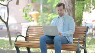 Boyun ağrısı olan genç adam laptopta çalışıyor.