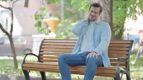 Müder Junger Mann Sitzt Mit Nackenschmerzen Freien — Stockvideo
