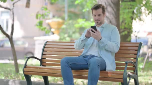 Junger Mann Feiert Erfolg Auf Dem Smartphone Während Draußen Auf — Stockvideo