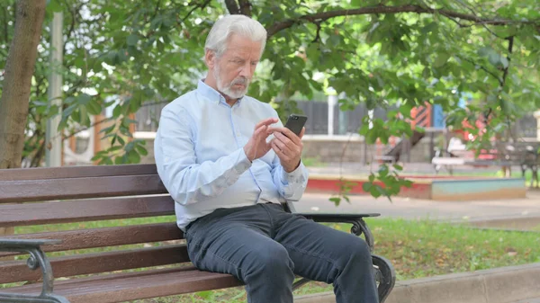 Senior Oude Man Met Behulp Van Smartphone Tijdens Het Zitten — Stockfoto