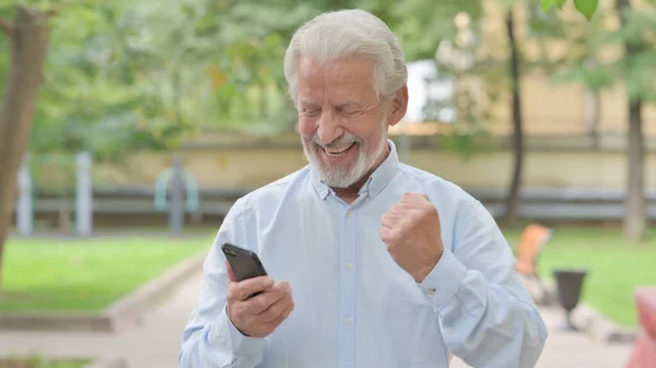 Starší Starý Muž Slaví Vítězství Smartphone Outdoor — Stock fotografie