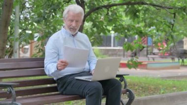 Üst düzey Yaşlı Adam Laptop ve Dokümanlar üzerinde çalışırken kutlama yapıyor
