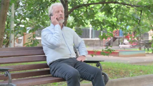Starší Stařec Mluví Telefonu Zatímco Sedí Venku Lavičce — Stock video