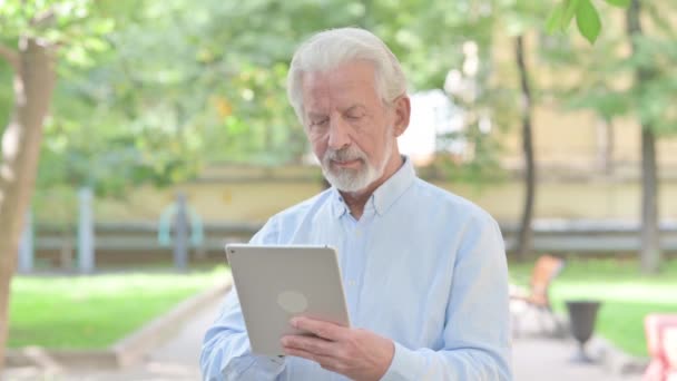 Senior Old Man Γιορτάζοντας Την Επιτυχία Στο Tablet Εξωτερική — Αρχείο Βίντεο