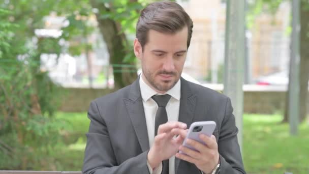 Fiatal Üzletember Ünnepli Győzelem Smartphone Outdoor — Stock videók