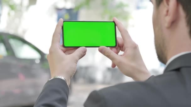 Junger Geschäftsmann Hält Telefon Mit Grünem Bildschirm Freien — Stockvideo