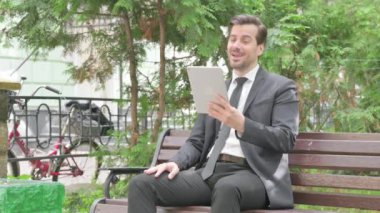 Orta Çağ İşadamı Tablet 'te Görüntü Sohbeti Yaparken Açık Bir Bençte Oturuyor
