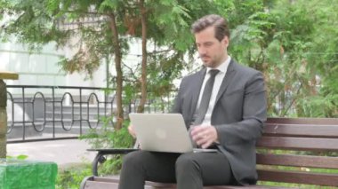 Orta yaşlı iş adamı dizüstü bilgisayarla çalıştıktan sonra yedek kulübesini terk etti