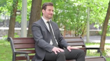 Kızgın genç işadamı Bench 'te oturuyor.