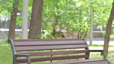 Genç İşadamı geliyor, Bench 'te oturuyor ve laptopta çalışıyor.