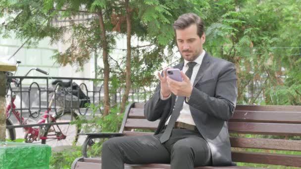 Empresário Meia Idade Chocado Com Perda Smartphone Enquanto Sentado Livre — Vídeo de Stock