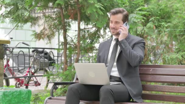 Середнього Віку Бізнесмен Розмовляючи Телефону Використовуючи Ноутбук Відкритому Повітрі — стокове відео