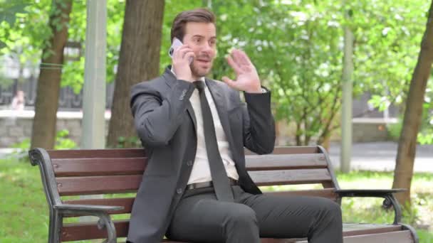 Zaklatott Fiatal Üzletember Vitatkozik Telefonon Miközben Szabadban Egy Padon — Stock videók