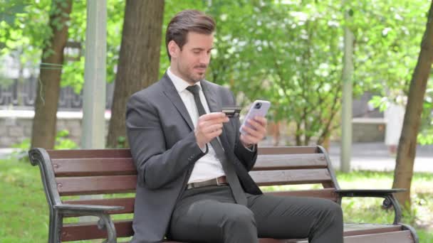 Молодий Бізнесмен Робить Онлайн Покупки Телефону Сидячи Відкритому Повітрі — стокове відео