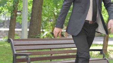 Genç İşadamı Ayağa kalktı ve Bench 'i açık havada bıraktı