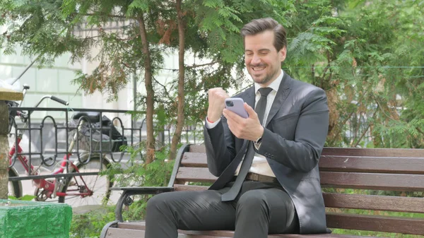 Empresário Meia Idade Comemorando Sucesso Smartphone Enquanto Sentado Livre Banco — Fotografia de Stock
