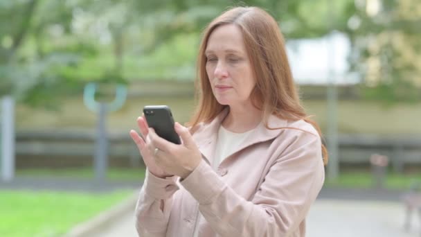 Upprörd Äldre Kvinna Blir Chockad Smartphone Outdoor — Stockvideo