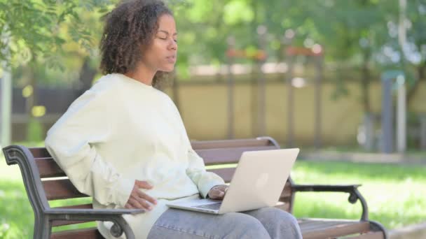 Молода Африканка Використовує Ноутбук Болем Спині Сидячи Відкритому Повітрі — стокове відео