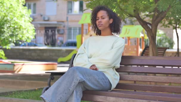 カジュアルなアフリカの女性が立ち上がり ベンチを屋外に残す — ストック動画