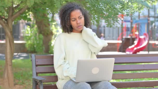 有颈部疼痛的非洲妇女在室外笔记本电脑上工作 — 图库视频影像