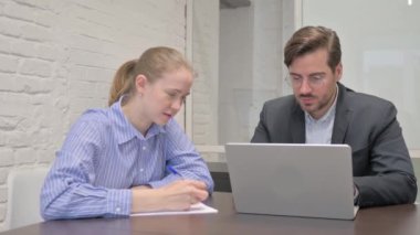 Ofiste dizüstü bilgisayarda çalışan iş adamları