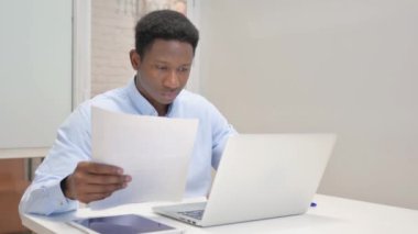 Dizüstü bilgisayar ve Belgeler Kullanılırken Afrikalı İşadamı Kutluyor