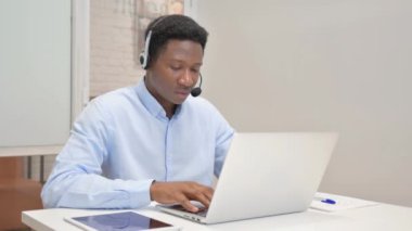 Kulaklıklı Afrikalı Çağrı Merkezi 'nde laptopta Video Sohbeti Yapıyor