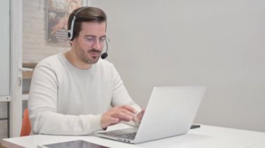 Kulaklıklı Genç Adam Çağrı Merkezi 'nde Laptop' ta Video Sohbeti Yapıyor