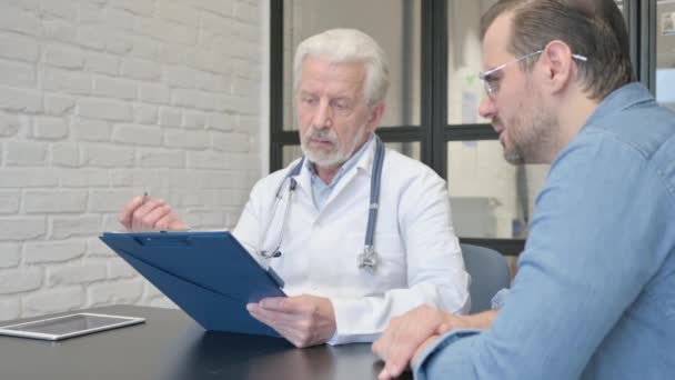 Пацієнт Реагує Погані Медичні Звіти Перед Старшим Лікарем — стокове відео