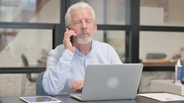 怒っている老人が職場で電話で話す — ストック動画