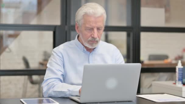 Alter Geschäftsmann Blickt Auf Kamera Während Büro Laptop Arbeitet — Stockvideo