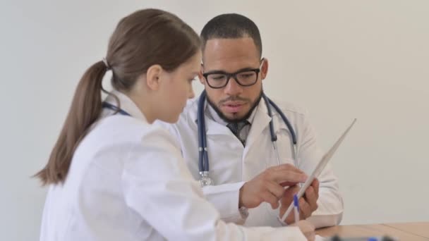 タブレットに関する医学レポートを議論する多民族医師のチーム — ストック動画