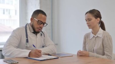 Baş ağrısı olan Afrikalı bir adam bir doktora danışmanlık yapıyor.