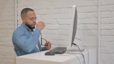 Bilgisayar üzerinde çalışırken karışık ırk adamının başı ağrıyor