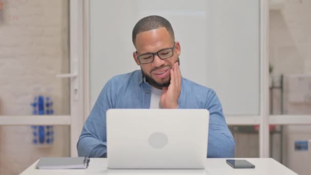 Gemengde Race Man Met Tandpijn Werken Laptop — Stockvideo
