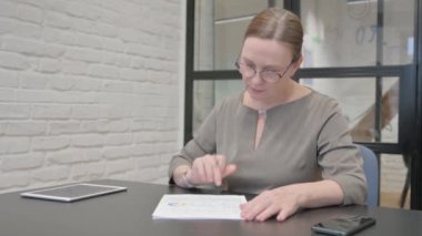 Belgeler ve İş Raporu üzerine çalışan Kıdemli Yaşlı Kadın