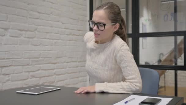 職場で座っている間に痛みを取り戻すクリエイティブな女性 — ストック動画