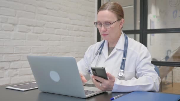 Velha Doutora Usando Laptop Telefone — Vídeo de Stock