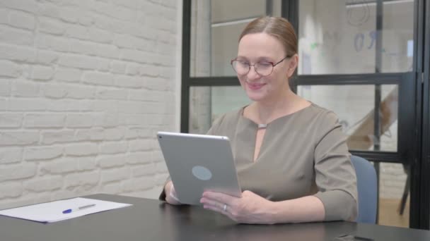オフィスのタブレット上でビデオチャットをする高齢女性 — ストック動画