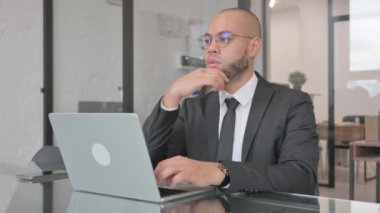 Laptop üzerinde çalışan Dalgın Karışık Yarış İşadamı