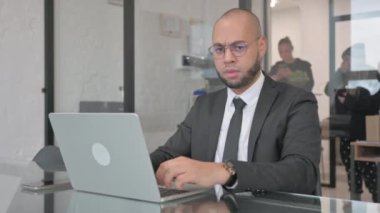 Dizüstü bilgisayar kullanırken Karışık Irk İşadamından Başparmak Düşürme