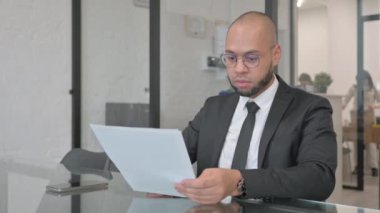 Karışık Irk İşadamı Sözleşme Okurken ÜzgünName